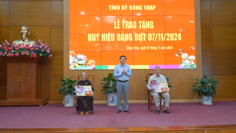 Phó Bí thư Thường trực Tỉnh ủy Đồng Tháp Phan Văn Thắng trao Huy hiệu 65 năm tuổi Đảng. (Ảnh: HỮU NGHĨA)