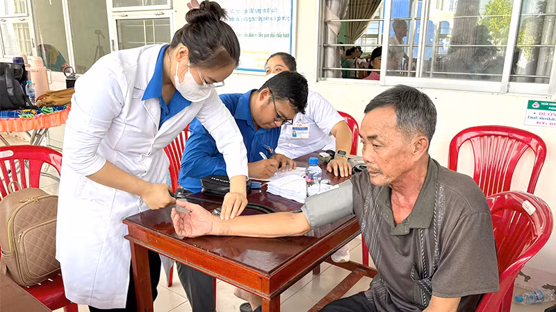Các y, bác sĩ tình nguyện khám bệnh miễn phí cho người dân xã Phú Điền, huyện Tháp Mười.