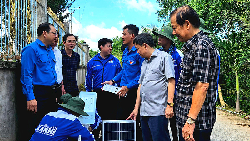 Các chiến sĩ tình nguyện thực hiện lắp trụ đèn chiếu sáng của công trình “Thắp sáng đường quê”.