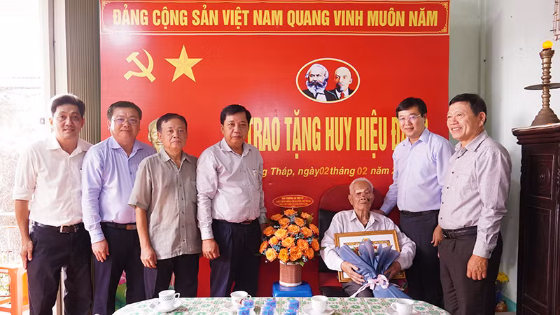 Bí thư Tỉnh ủy Đồng Tháp Lê Quốc Phong trao Huy hiệu 75 năm tuổi Đảng tặng đảng viên Nguyễn Việt Hùng.