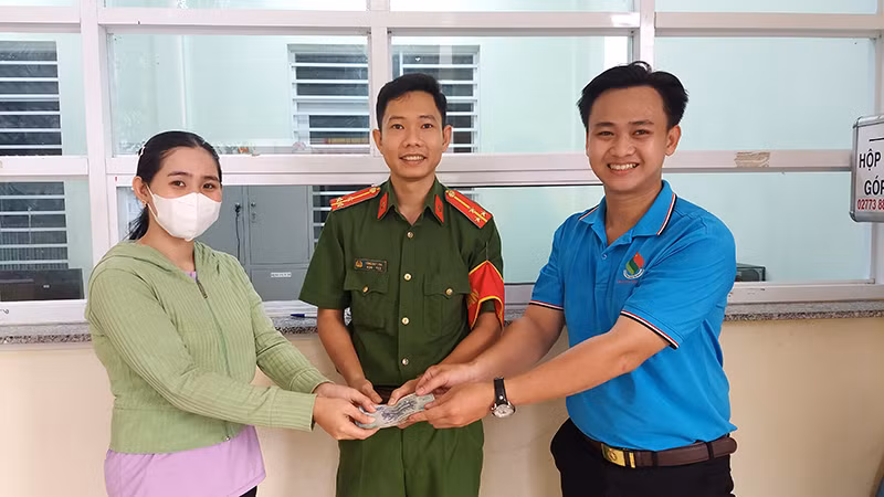 Công an phường 6 và anh Nguyễn Minh Toàn bàn giao lại chiếc ví cho chị Lê Thị Huỳnh Oanh.