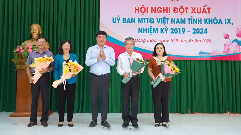 Đồng chí Đinh Văn Dũng (thứ 2 từ phải qua) nhận hoa chúc mừng của Bí thư Tỉnh ủy Đồng Tháp Lê Quốc Phong. (Ảnh: HỮU NGHĨA)