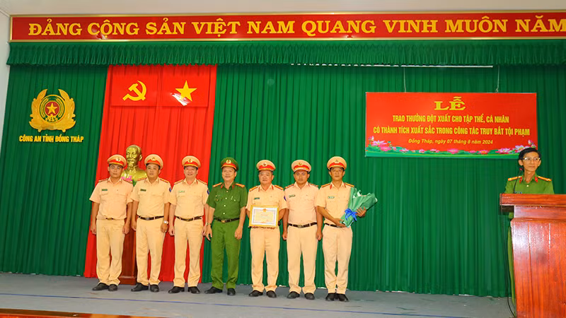 Lãnh đạo Công an huyện Cái Bè, tỉnh Tiền Giang và lãnh đạo Phòng Cảnh sát giao thông, Công an tỉnh Đồng Tháp trao giấy khen cho tập thể có thành tích trong bắt các đối tượng cướp và cố ý gây thương tích. (Ảnh: PHƯỚC THANH)