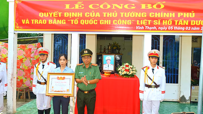 Đại tá Nguyễn Văn Hiểu, Giám đốc Công an tỉnh Đồng Tháp trao Bằng “Tổ quốc ghi công” cho vợ Liệt sĩ Hồ Tấn Dương.