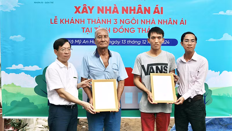  Nhà báo Nguyễn Xuân Toàn, Phó Tổng Biên tập báo Dân trí (bìa trái) và ông Trương Minh Quí, Phó Chủ tịch Ủy ban nhân dân xã Mỹ An Hưng B trao quyết định bàn giao nhà Nhân ái tới 2 hộ dân ở xã Mỹ An Hưng B.