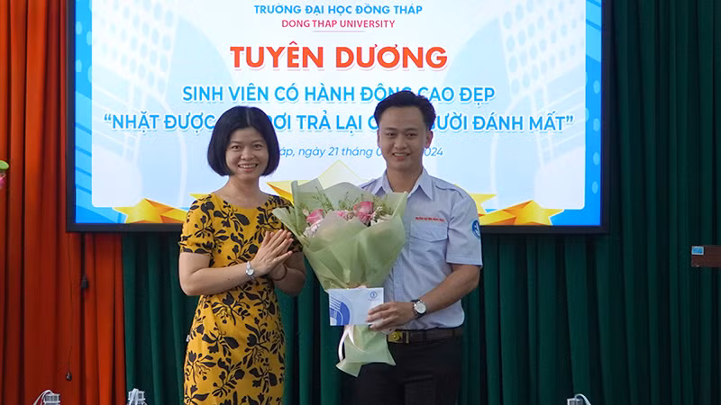 Lãnh đạo Khoa Giáo dục tiểu học - mầm non tặng hoa và tiền thưởng cho sinh viên Nguyễn Minh Toàn. (Ảnh: HỮU NGHĨA)