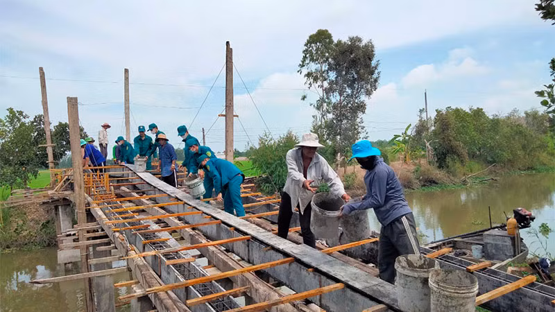 Quân và dân xã Đốc Binh Kiều chung tay xây dựng cầu nông thôn. (Ảnh: HOÀNG KHA)