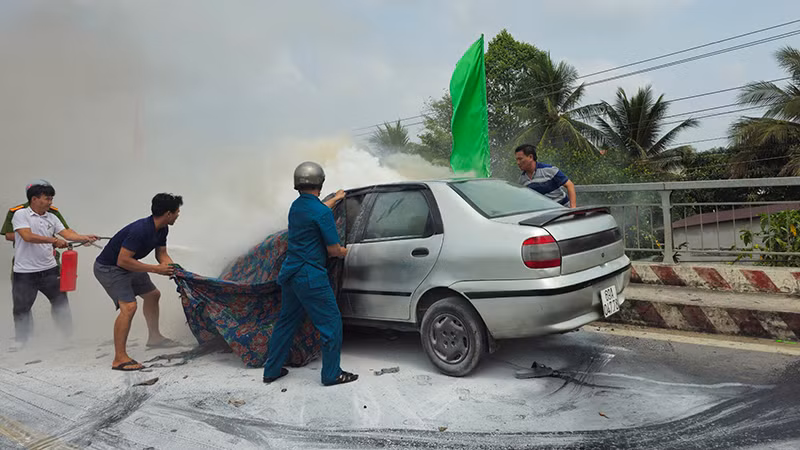 Nhiều người dân và lực lượng chức năng tham gia dập tắt đám cháy. (Ảnh HỮU NGHĨA)