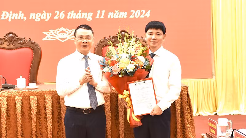 Đồng chí Bí thư Tỉnh ủy Nam Định Đặng Khánh Toàn trao quyết định và chúc mừng đồng chí Nguyễn Hoàng Anh được Ban Bí thư Trung ương Đảng chỉ định tham gia Ban Chấp hành Đảng bộ tỉnh Nam Định nhiệm kỳ 2020-2025. (Ảnh: XUÂN TRƯỜNG)