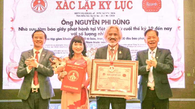 Ông Nguyễn Phi Dũng nhận chứng nhận xác lập kỷ lục nhà sưu tầm báo giấy từ đại diện Tổ chức kỷ lục Việt Nam.
