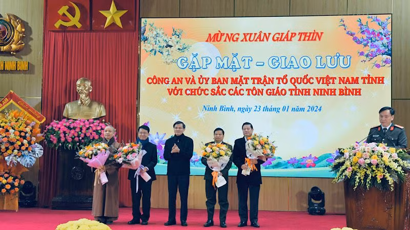 Đồng chí Đoàn Minh Huấn, Ủy viên Trung ương Đảng, Bí thư Tỉnh ủy Ninh Bình tặng hoa, chúc mừng đại diện các tổ chức tôn giáo và lãnh đạo Công an tỉnh, Ủy ban Mặt trận Tổ quốc tỉnh Ninh Bình. Ảnh: XUÂN TRƯỜNG