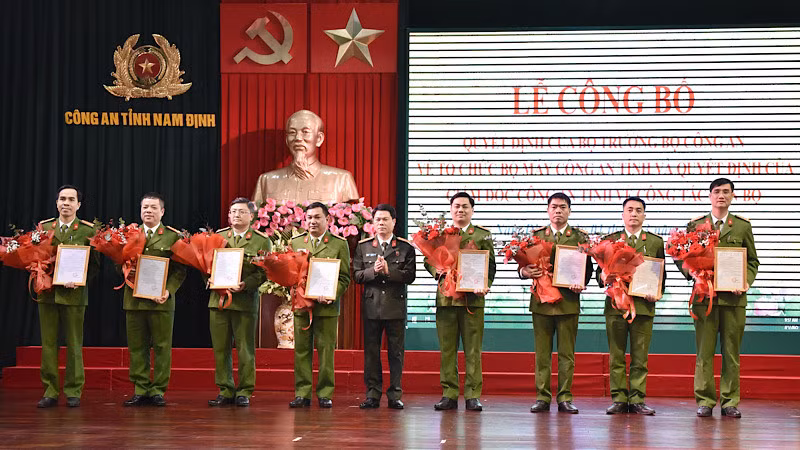 Đại tá Nguyễn Hữu Mạnh, Giám đốc Công an tỉnh Nam Định trao quyết định, tặng hoa chúc mừng các đồng chí nhận công tác mới. 