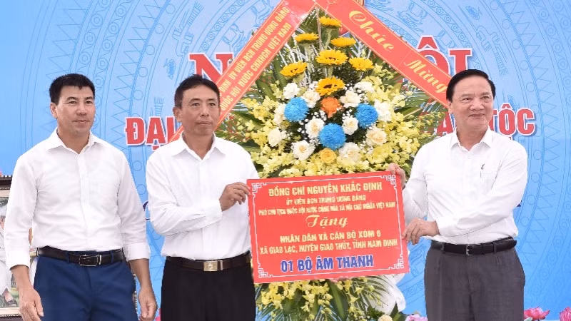 Phó Chủ tịch Quốc hội Nguyễn Khắc Định tặng hoa và quà chúc mừng cán bộ, nhân dân xóm 6, xã Giao Lạc, huyện Giao Thủy, Nam Định. (Ảnh: XUÂN TRƯỜNG).