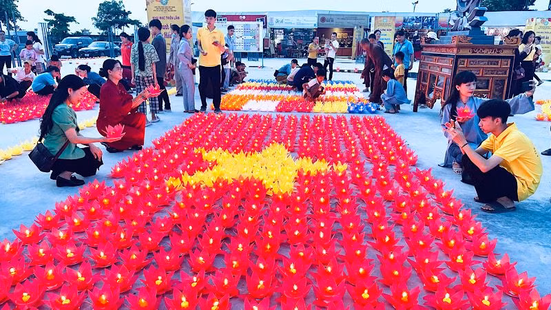 Người dân thắp nến tạo hình lá cờ Tổ quốc tại Chương trình. (Ảnh: XUÂN TRƯỜNG)