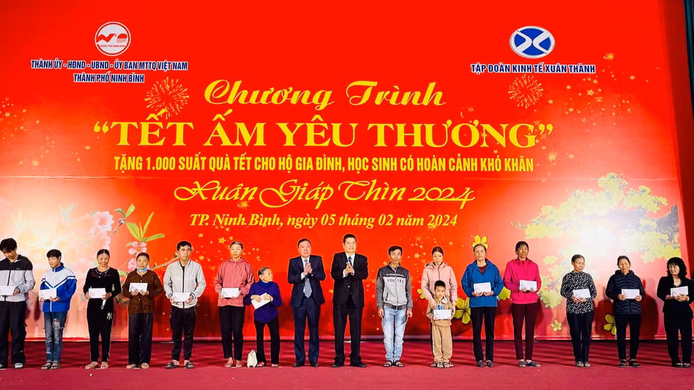 Lãnh đạo thành phố Ninh Bình cùng lãnh đạo Tập đoàn kinh tế Xuân Thành trao tặng các phần quà đến các hộ gia đình, học sinh có hoàn cảnh khó khăn trên địa bàn. (Ảnh: Yến Trinh)
