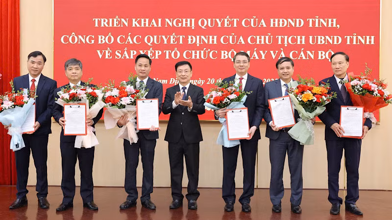 Đồng chí Phạm Đình Nghị, Chủ tịch Ủy ban nhân dân tỉnh Nam Định trao Quyết định và tặng hoa chúc mừng tập thể lãnh đạo Sở Nội vụ. (Ảnh: XUÂN TRƯỜNG)