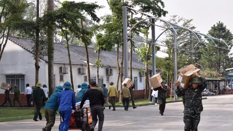 Các lực lượng phối hợp di chuyển hàng hóa khỏi khu vực cháy. (Ảnh: XUÂN TRƯỜNG)