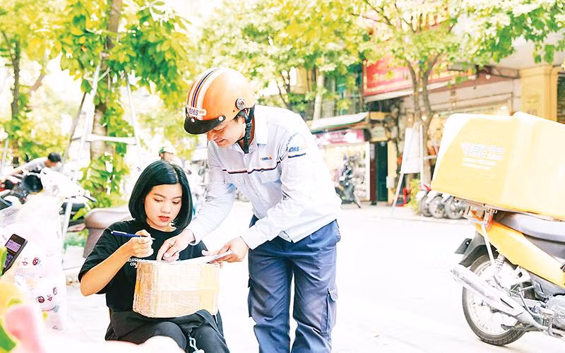 Nhân viên của EMS giao bưu phẩm tận tay khách hàng.