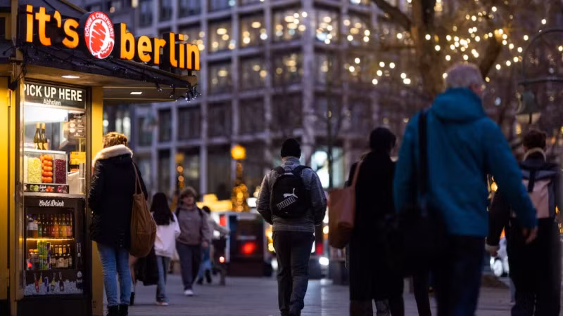 Người dân đi bộ cạnh gian hàng Doner kebab và Currywurst tại phố mua sắm Kurfuerstendamm trong mùa Giáng sinh ở Berlin, Đức. (Ảnh: REUTERS)
