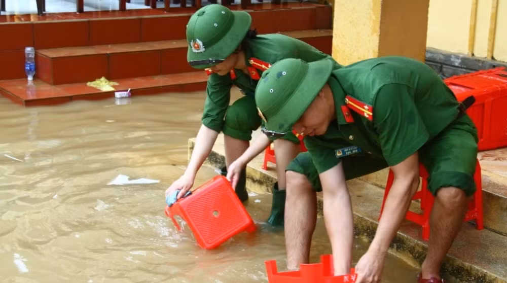 Đoàn viên thanh niên Công an tỉnh Quảng Bình giúp trường học vùng lũ vệ sinh trường lớp, lau rửa bàn ghế.