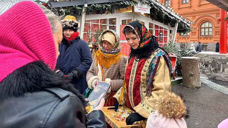 Những người phụ nữ bán kẹo mặc đồ dân tộc truyền thống.