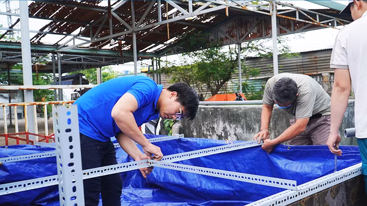 Quốc Vương (bên trái) đang lắp đặt bể lọc di động tại một đơn vị.