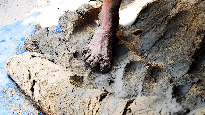 Nhào nguyên liệu từ đất sét, cát và nước.