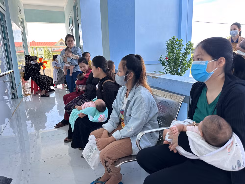 Bà mẹ và trẻ em ngồi chờ tiêm vaccine tại Trạm y tế xã Cam Tuyền.