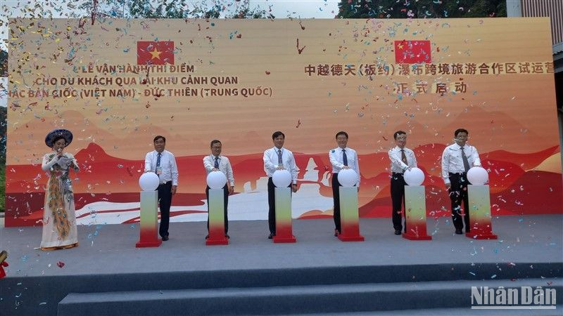 Các đại biểu thực hiện nghi thức vận hành thí điểm cho du khách qua lại tham quan thác Bản Giốc-Đức Thiên.