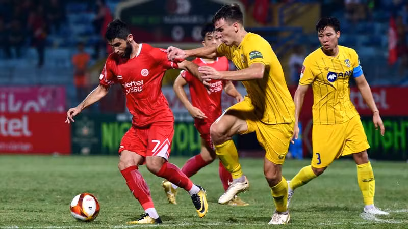Pha bóng giữa cầu thủ đội Viettel FC (áo đỏ) và đội Sông Lam Nghệ An. (Ảnh TRẦN HẢI)