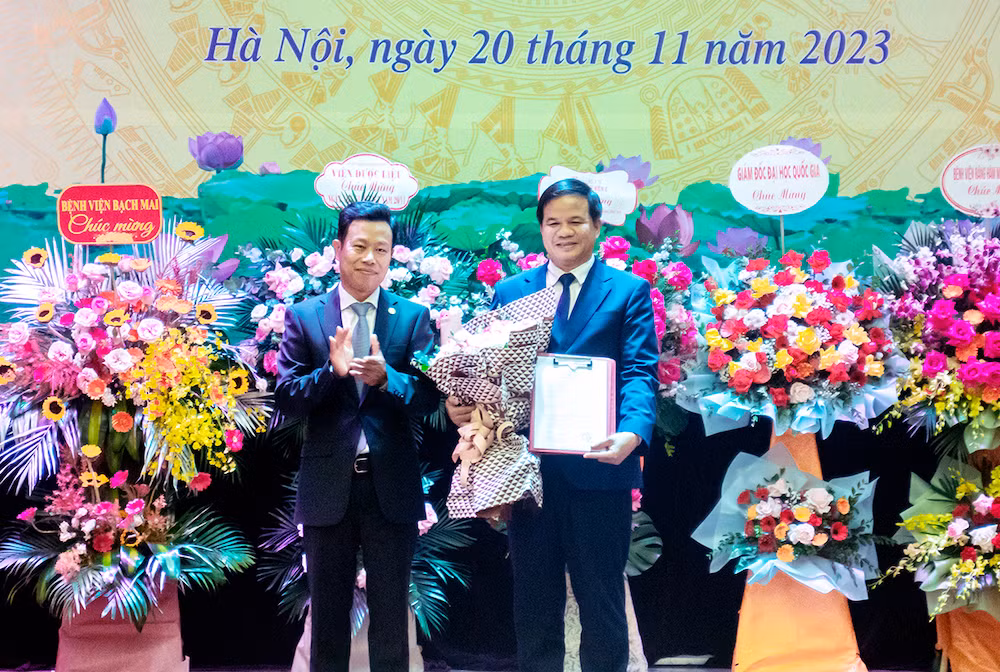 Giám đốc Đại học Quốc gia Hà Nội Lê Quân (bên trái) trao quyết định bổ nhiệm chức vụ Phó Hiệu trưởng Trường đại học Y Dược, Đại học Quốc gia Hà Nội cho Giám đốc Bệnh viện Bạch Mai Đào Xuân Cơ.