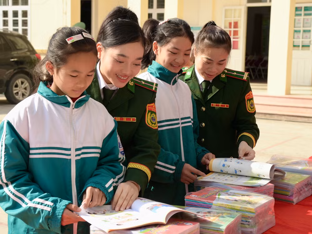 Nữ chiến sĩ Bộ đội Biên phòng tỉnh Lạng Sơn tặng sách cho thiếu nhi biên giới.