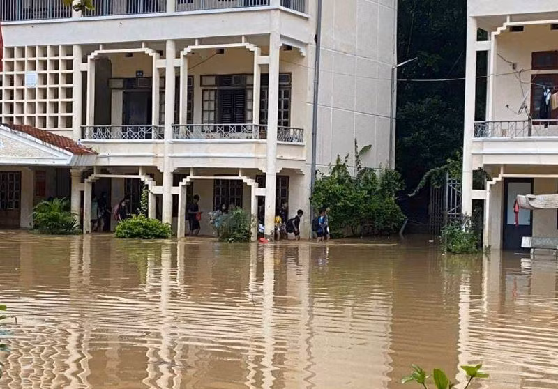 Các em học sinh phải di dời do nước lũ ngập cao.