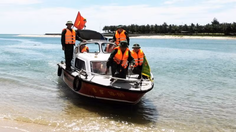 Xuồng của Đồn Biên phòng Nhật Lệ tiếp cận, đưa 4 ngư dân được cứu vào bờ.