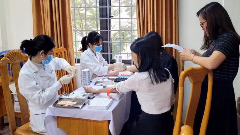 Nhân viên MEDLATEC Quảng Bình lấy mẫu xét nghiệm cho giáo viên một trường trung học phổ thông ở thành phố Đồng Hới.