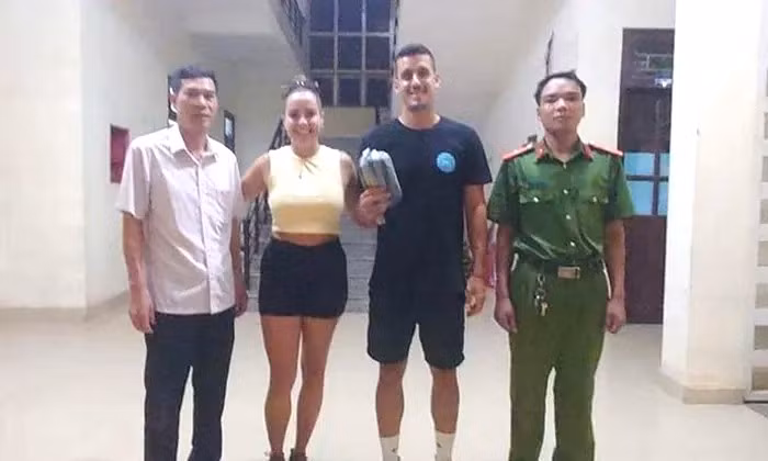 Hai du khách Tây Ban Nha nhận lại tài sản đánh rơi. (Ảnh: Công an cung cấp)