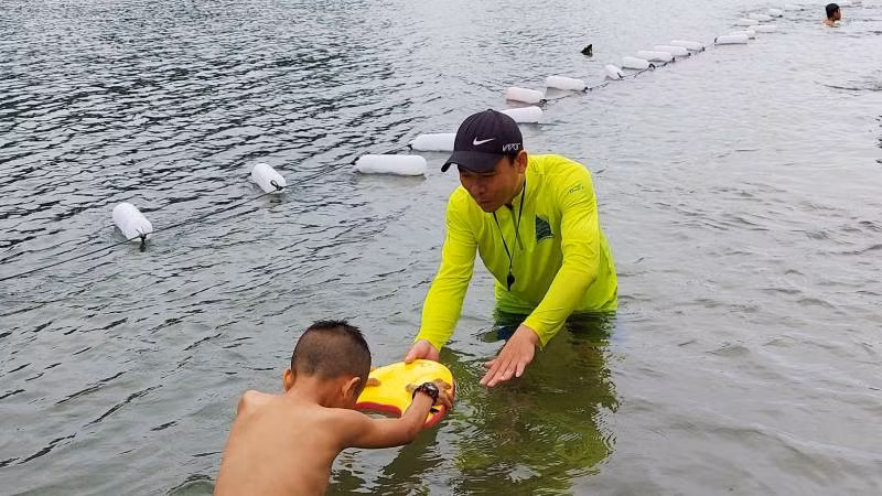 Kỹ thuật viên của Công ty du lịch Chua me đất dạy bơi cho trẻ em ở thị trấn Phong Nha.