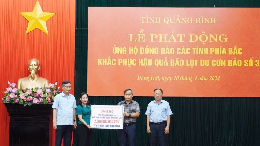 Các đồng chí trong Thường trực Tỉnh ủy Quảng Bình trao biển tượng trưng hỗ trợ 2,5 tỷ đồng cho các tỉnh phía bắc khắc phục hậu quả thiên tai.