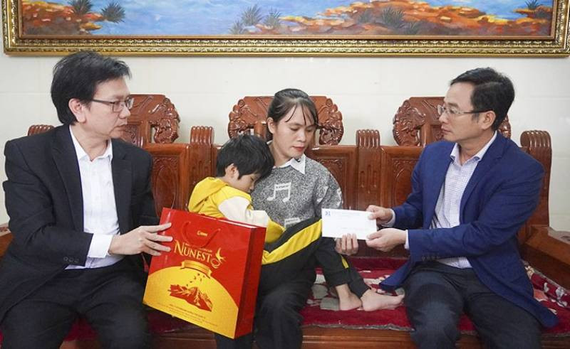 Giám đốc Sở Giáo dục-Đào tạo Quảng Bình Đặng Ngọc Tuấn (bên phải) thăm, tặng quà cô Nguyễn Thị Huế, giáo viên Trường mầm non Nam Lý, thành phố Đồng Hới. Cô Huế bị bệnh nặng, lại phải nuôi con nhỏ bị mù bẩm sinh. 