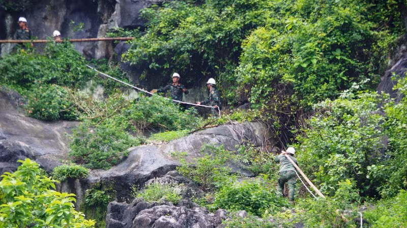 Lực lượng công binh của Bộ Chỉ huy Quân sự Quảng Bình dùng mìn phá hủy và đưa khối đá trượt từ trên cao xuống dưới chân núi an toàn.