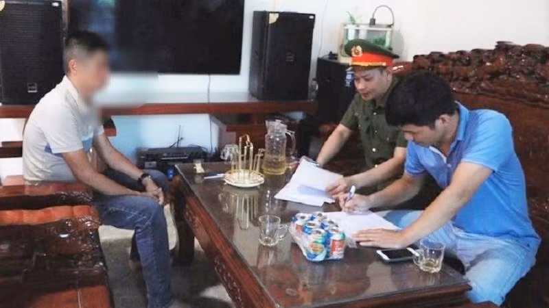 Công an làm việc với 1 đối tượng trong đường dây đánh bạc.