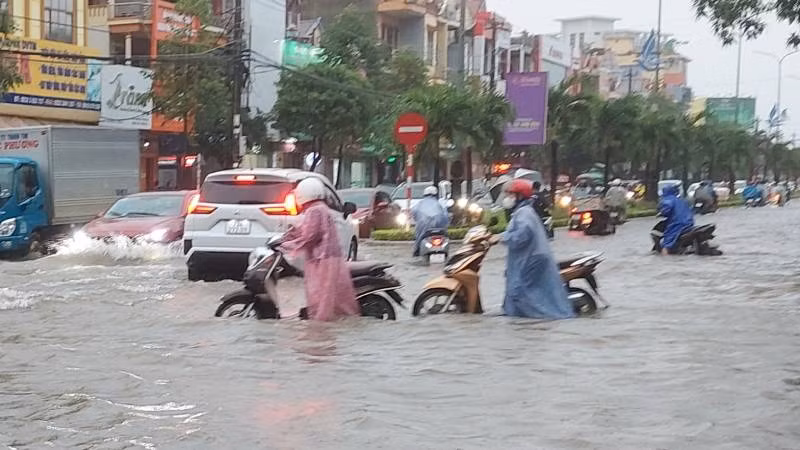 Xe chết máy, nhiều người phải dắt bộ lội qua đoạn đường phố ngập.