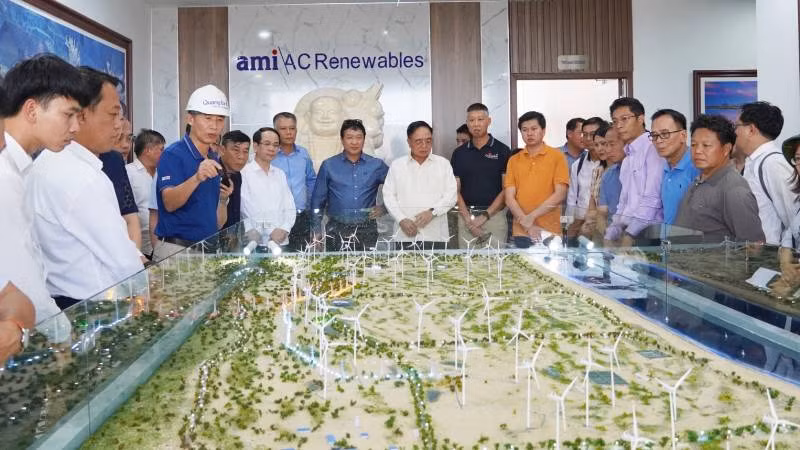 Bộ trưởng Khamchen Vongphosy (áo trắng đứng giữa) nghe giới thiệu tổng quan về cụm trang trại điện gió B&T. 