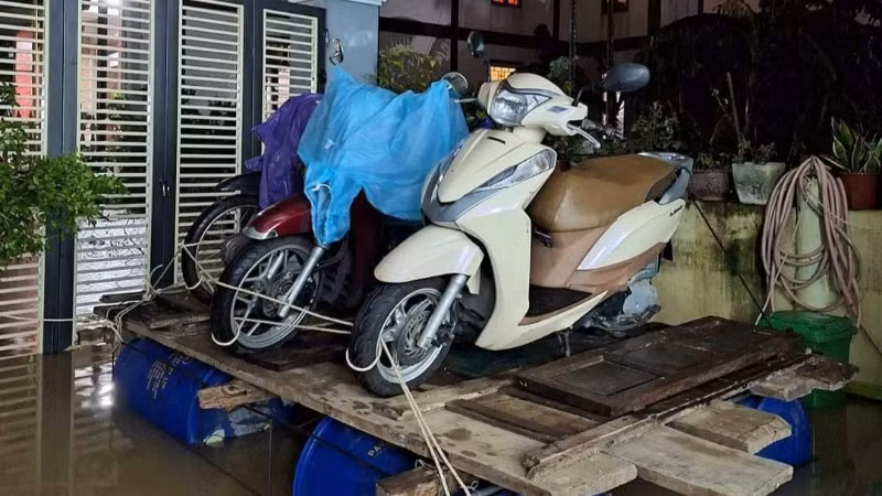 Người dân "sáng kiến" ra mô hình đưa xe máy lên trên phao nổi để tránh bị thiệt hại do nước lũ (Ảnh: CTV)