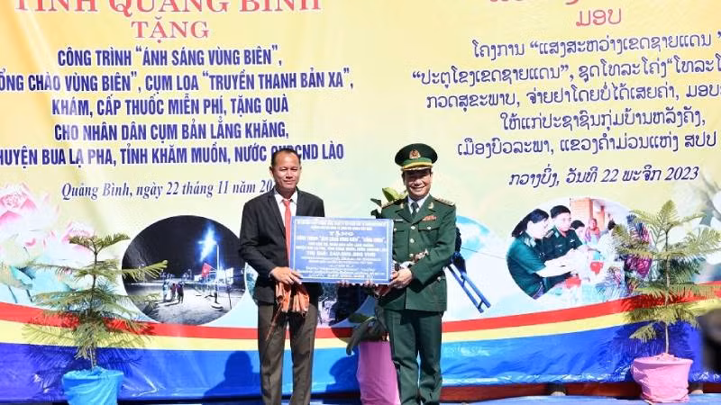 Đại tá Trịnh Thanh Bình, Chỉ huy trưởng Bộ Chỉ huy Bộ đội Biên Quảng Bình, trao bảng tượng trưng quà tặng cho cụm bản của nước bạn Lào