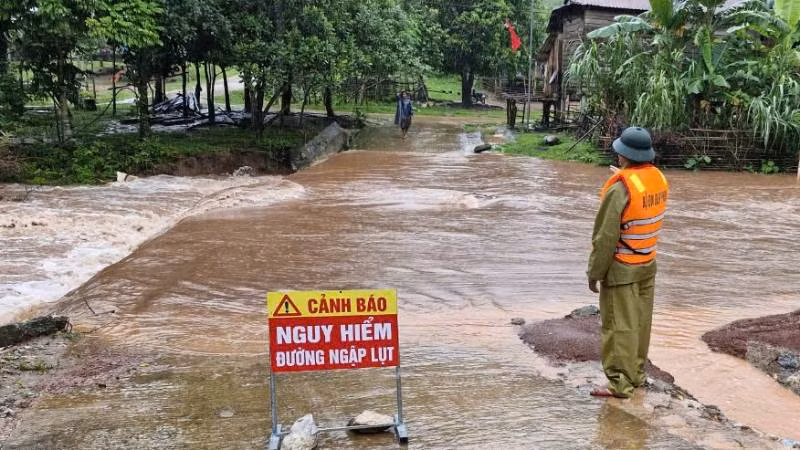 Một tuyến đường ở xã Thượng Trạch, huyện Bố Trạch bị ngập sâu, lực lượng chức năng đặt biển cảnh báo và chốt trực không cho người qua lại.