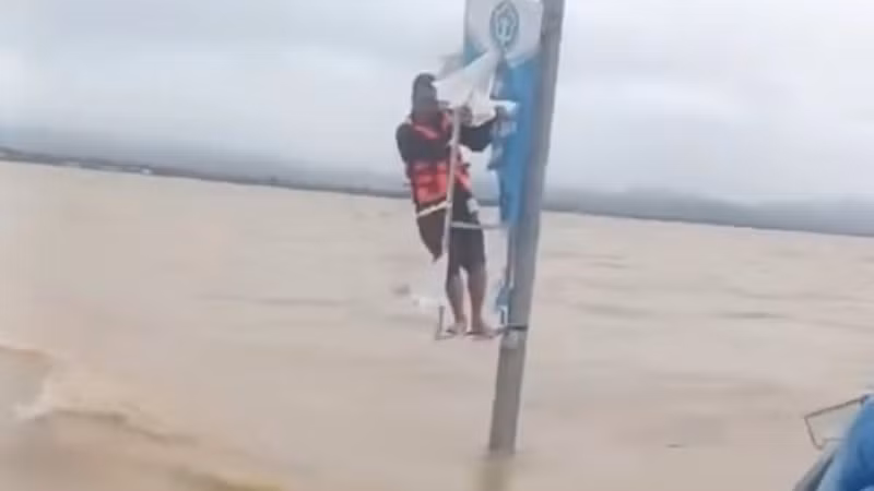 Ông Trương Văn Duy đu bám vào cột điện xuyên đêm giữa lũ đến sáng nay thì được cứu.