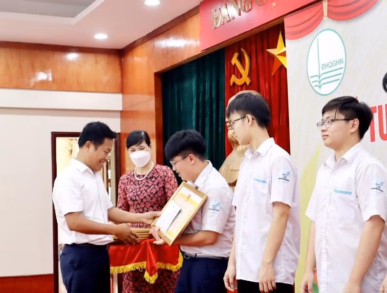 Lãnh đạo Đại học Quốc gia Hà Nội trao thưởng cho học sinh giành huy chương Olympic quốc tế.