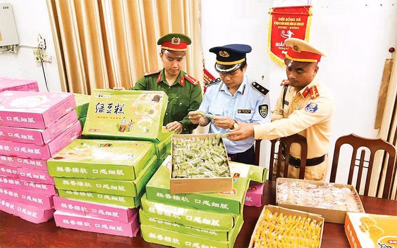 Các lực lượng chức năng kiểm tra hàng hóa vi phạm trong vụ việc vận chuyển 5.075 chiếc bánh Trung thu không rõ nguồn gốc, xuất xứ tại xã Song Khê, thành phố Bắc Giang, tỉnh Bắc Giang. (Ảnh Cục Quản lý thị trường tỉnh Bắc Giang) 