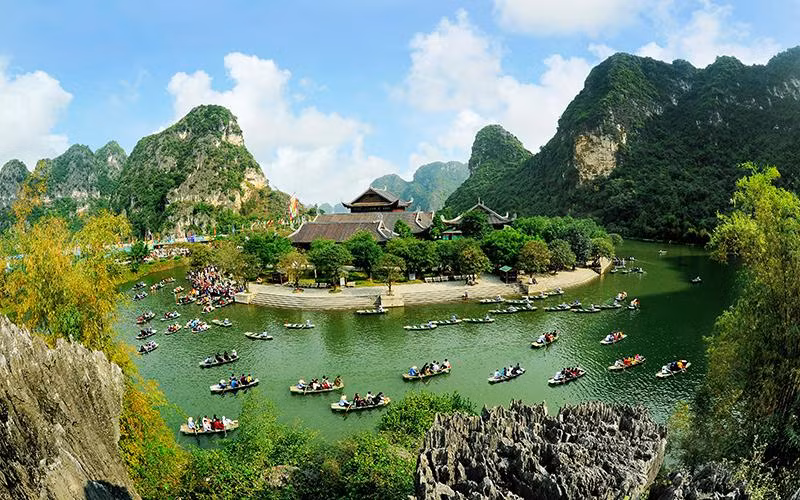 Du khách tham quan Di sản Văn hóa và Thiên nhiên thế giới Tràng An. (Ảnh NINH MẠNH THẮNG) 